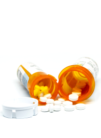 Photo of two opioid pill bottles laying on their sides with lids off and pills spilling out of the bottles.